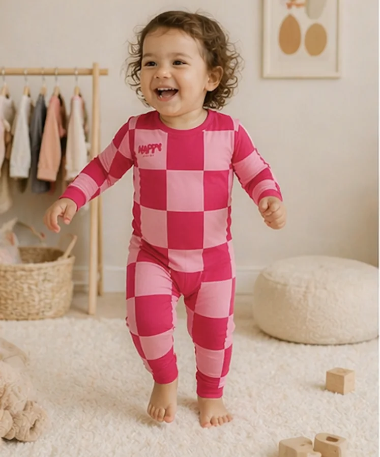 A laughing toddler in Berry Sweet bamboo pajamas
