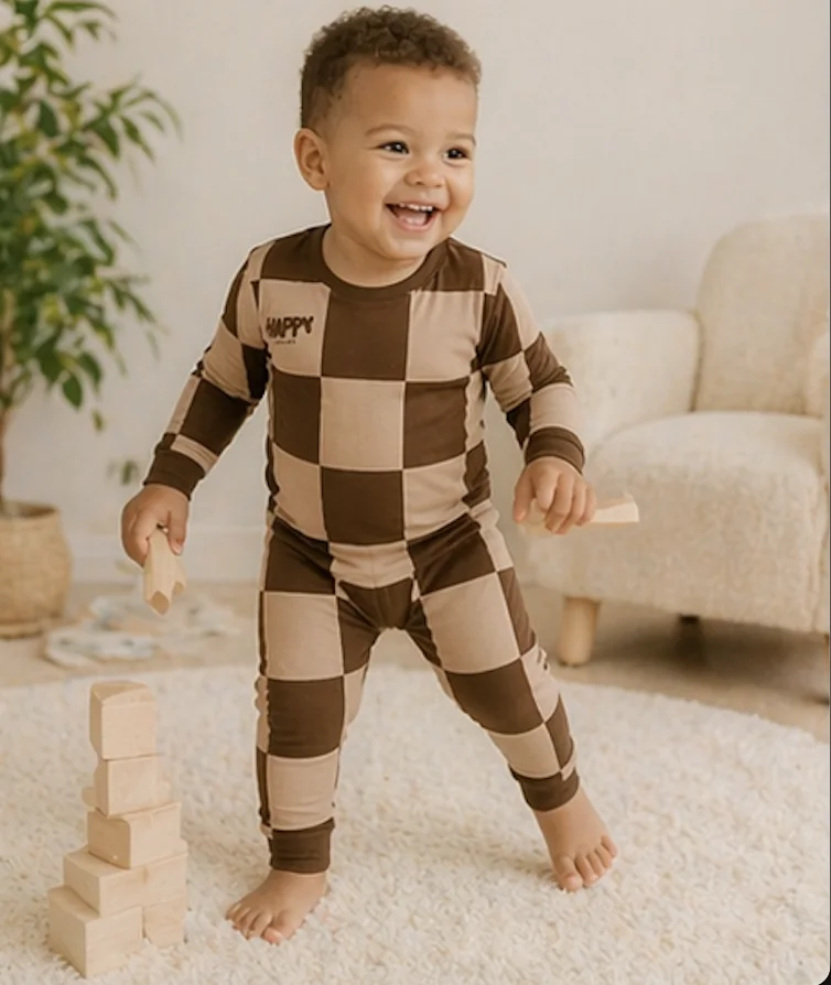 A toddler in Cocoa Cozy bamboo pajamas playing with wooden blocks